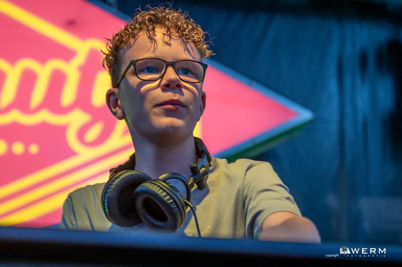DJ Nori achter de draaitafel met een koptelefoon om zijn nek